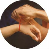 Rød tråd på håndleddet - som betyr å binde og bære