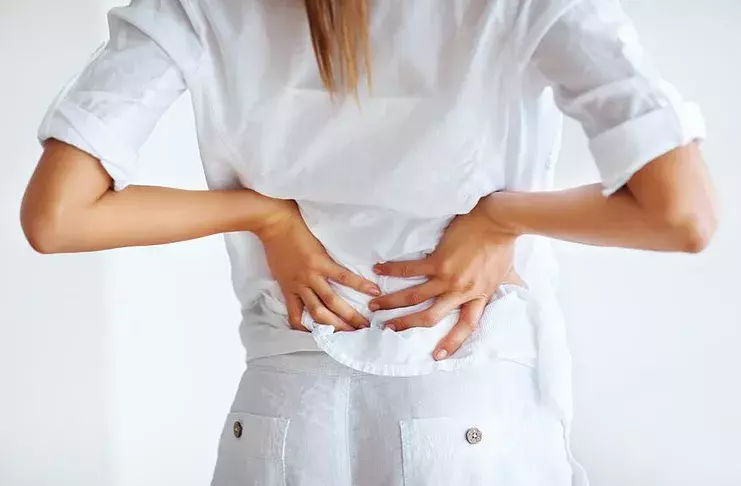 Waarom doet de onderrug (rug) pijn tijdens de menstruatie: redenen