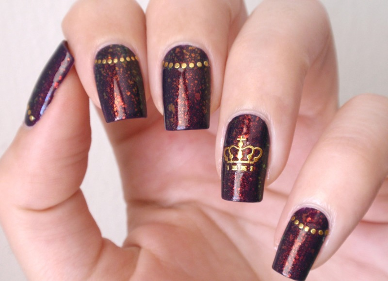 Coroa nas unhas: desenho, strass, pedras, adesivos, moldagem. Design de manicure vermelho, preto, amarelo, ouro e branco bonito com coroa em unhas: foto